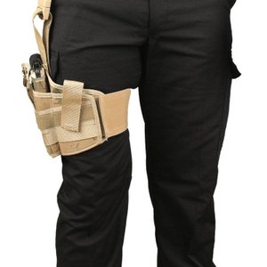 May include: A tan tactical thigh holster with multiple pouches and a strap. The holster is attached to a leg and is designed to hold a handgun. The leg is covered in black pants.