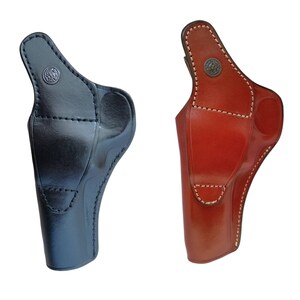 Peut inclure: Deux &eacute;tuis en cuir pour pistolet. L'un est noir, l'autre est brun rouge&acirc;tre. Les deux ont un design moul&eacute; avec un dessus incurv&eacute;, un bouton en m&eacute;tal et des coutures blanches. Les &eacute;tuis sont con&ccedil;us pour &ecirc;tre port&eacute;s &agrave; la hanche.