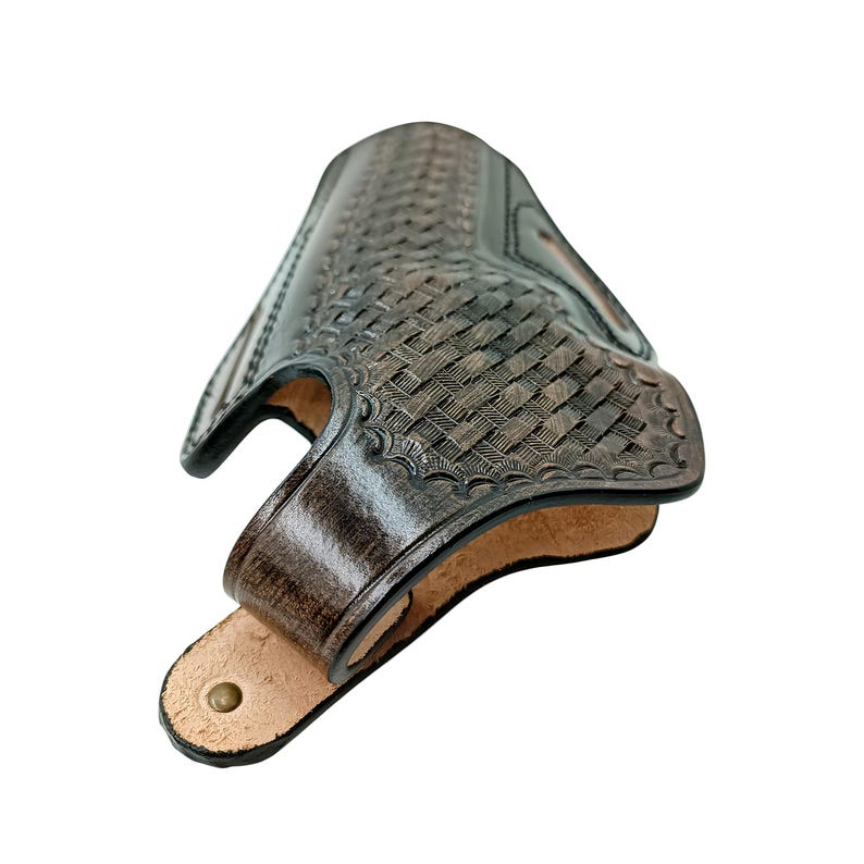 Op de afbeelding: Een donkerbruin leren holster met een mandweefpatroon. Het holster heeft een gebogen vorm met een riemlus en een messing klinknagel. De binnenkant is lichtbruin.