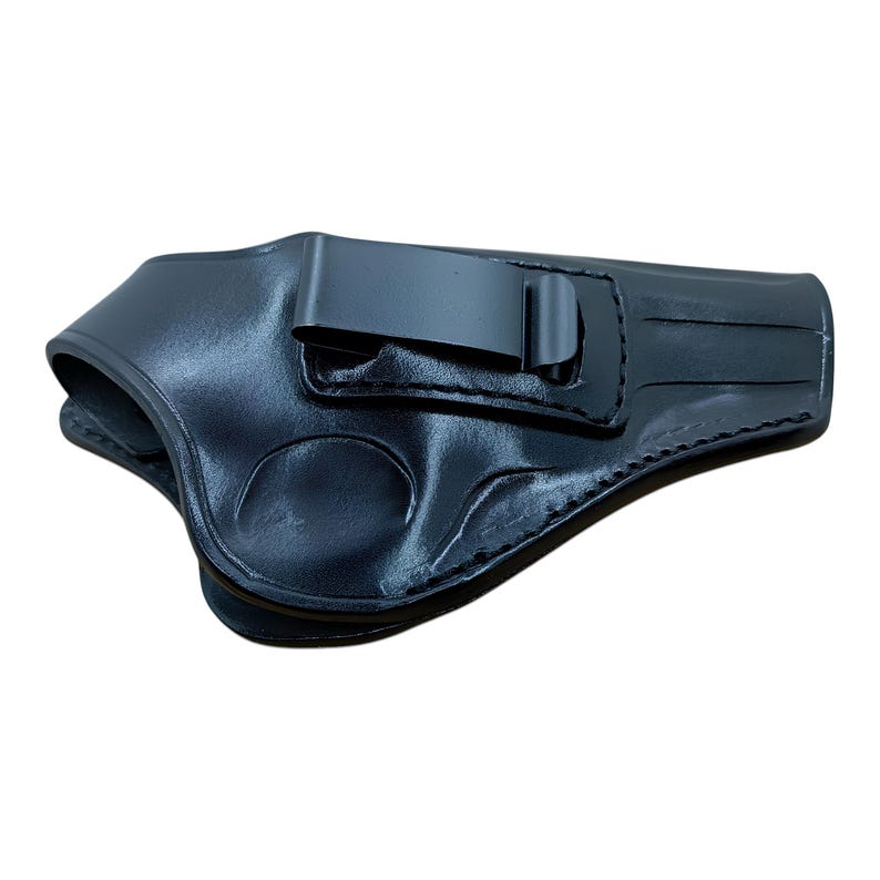 K&ouml;nnte beinhalten: Schwarze Lederholster mit Metallclip. Die Holster ist f&uuml;r das Tragen im Hosenbund konzipiert. Das Leder hat eine glatte, leicht gl&auml;nzende Oberfl&auml;che.