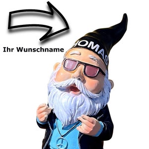 Peut inclure: Un gnome de jardin bleu et noir portant des lunettes de soleil et un chapeau noir avec le mot "OMAS" dessus. Le gnome porte un collier avec un symbole de paix et a une barbe blanche.