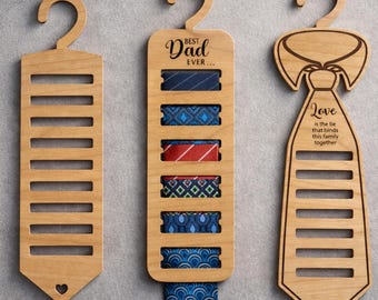 May include: Three wooden tie organizers with a natural finish. One has a heart cutout, another says "Best Dad Ever...", and the third says "Love is the tie that binds this family together". Each organizer has slots for ties.