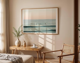 Puede incluir: Una impresión enmarcada de un paisaje marino con surfistas en el océano. La obra de arte se exhibe sobre un escritorio de madera con un jarrón y objetos decorativos. La habitación tiene una paleta de colores neutros con luz natural.