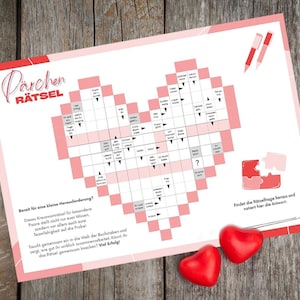 Puede incluir: Un crucigrama en forma de corazón, con la palabra alemana "Pärchen Rätsel" en la parte superior. Dos caramelos rojos en forma de corazón están debajo sobre una superficie de madera.