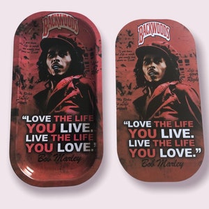 May include: A red metal rolling tray with a black and white image of Bob Marley and the quote "Love the life you live. Live the life you love." The tray has the words "Backwoods" printed in white on a black background.