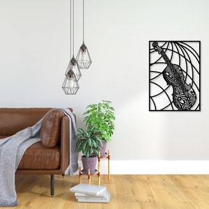 May include: Black metal wall art featuring a detailed, intricate design of a violin. The violin is set against a background of curved lines, creating a dynamic and modern aesthetic.