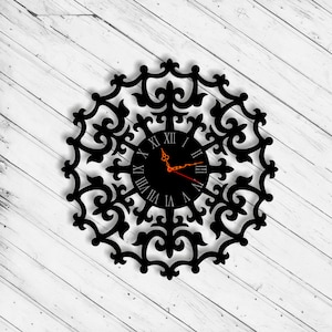 May include: Black clock with Roman numeral markings on a black background. The clock face is surrounded by a decorative, intricate, black, metal frame.