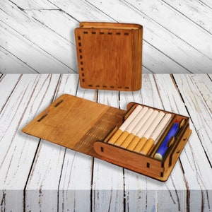 May include: A wooden box with a hinged lid, designed to hold cigarettes. The box is open, revealing a row of cigarettes and a small blue compartment.
