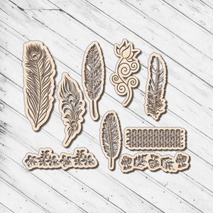 Può includere: Un set di 10 disegni in legno tagliati al laser con piume, fiori e volute. I disegni sono intricati e dettagliati e sarebbero perfetti per progetti di artigianato.