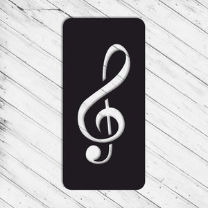 Puede incluir: Una tarjeta rectangular negra con un diseño de clave de sol blanca. El símbolo musical tiene una apariencia texturizada y tridimensional, sobre un fondo negro. La tarjeta está colocada sobre una superficie de madera blanca.