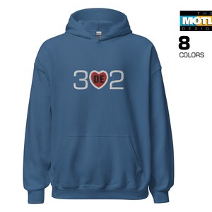 May include: A blue hooded sweatshirt with a white graphic of the number 302 with a red heart in the middle. The heart has the letters DE inside.