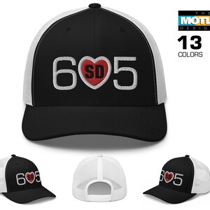May include: A black and white trucker hat with a white embroidered '605' and a red heart with 'SD' inside. The hat is available in 13 colors.