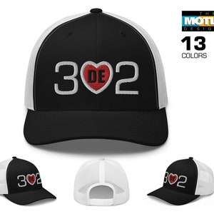 May include: A black and white trucker hat with a red heart and the text "302" in white. The hat is available in 13 colors.