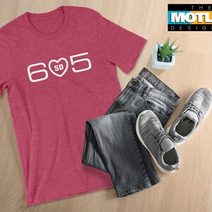 May include: A red heather t-shirt with a white graphic of the number 605 with a heart in the middle that says "SD".