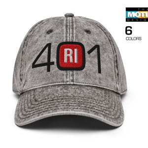 Puede incluir: Una gorra de béisbol gris desgastada con un parche bordado en rojo y negro que dice "RI" y los números "401" en la parte delantera.