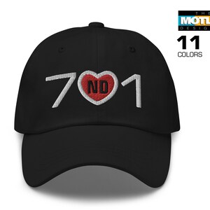 Op de afbeelding: Zwarte baseballpet met witte geborduurde tekst "701" en een rood hart met "ND" erin.