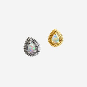 Peut inclure: Deux boucles d'oreilles en forme de goutte avec des opales irisées serties dans du métal. L'une est en métal argenté avec un bord perlé, tandis que l'autre est en métal doré avec un design texturé et perlé assorti sur le pourtour.