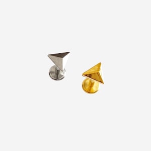 May include: Two stud earrings, one silver and one gold, each with a triangular design. The earrings have a flat back and a post for piercing. The gold earring has a shiny finish, the silver one a matte finish.
