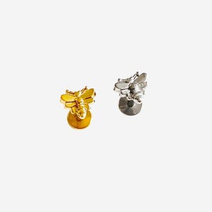 May include: Two bee-shaped stud earrings, one finished in a polished gold tone and the other in a polished silver tone. Each earring features a detailed insect design with wings and a body, attached to a flat circular backing post for secure wear.