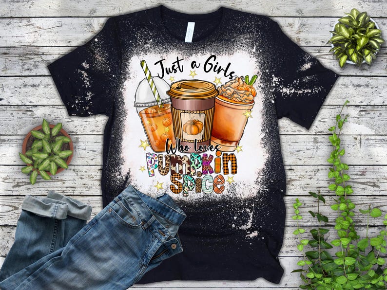 Może przedstawiać: Czarny T-shirt z wybielonym wzorem przedstawiającym trzy jesienne napoje i tekst "Just a Girls Who Loves Pumpkin Spice".