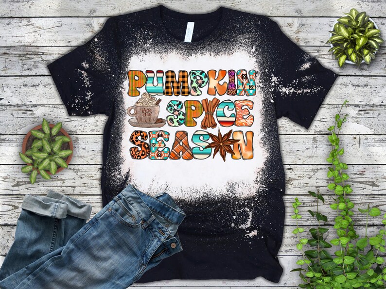 May include: Black t-shirt with a white bleach design that says "Pumpkin Spice Season" in colourful letters. The design includes a cup of coffee, cinnamon sticks, and a star anise.
