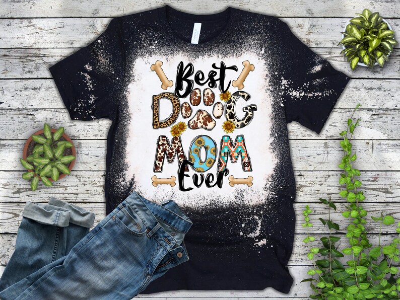 以下が含まれることがあります： 「Best Dog Mom Ever」と書いてある、漂白されたデザインの黒いTシャツ。デザインには、ヒョウ柄、牛柄、ひまわりなど、さまざまなパターンが施された肉球のプリントが施されています。