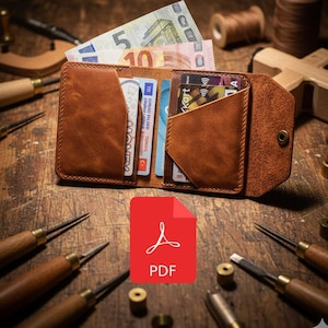 May include: Open tan leather wallet containing banknotes and credit cards. The wallet sits on a wooden surface, surrounded by leatherworking tools. A red PDF icon is in the foreground.