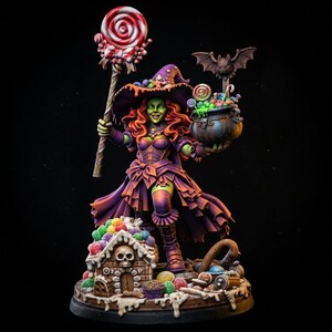 May include: A miniature figurine of a green-skinned character wearing a purple hat and dress, holding a large red and white swirl lollipop and a cauldron filled with sweets. A small gingerbread house with a skull sits at the base with sweets.