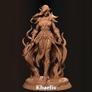 May include: A detailed brown figurine of a female fantasy character, standing on a rocky base. The figure is clad in ornate armour and flowing garments, with long hair and pointed ears. The name "Khaelis" is printed at the base.