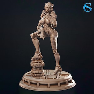 May include: A beige figurine of a female warrior in a futuristic suit, holding a weapon. The figure is posed on a circular platform with mechanical details, suggesting a science fiction or fantasy theme. The sculpture has intricate details.