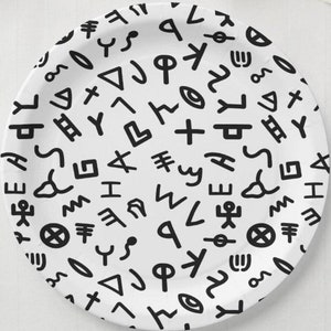 May include: White paper plate featuring a black and white pattern of abstract symbols. The symbols are repeated in a random pattern across the entire surface of the plate.