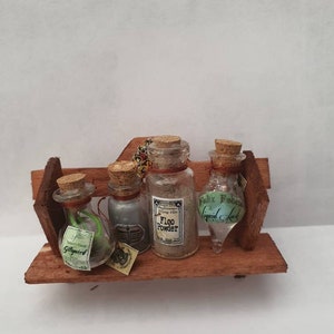4 miniature potions bottles and 2 magical books on a lovely shelf.