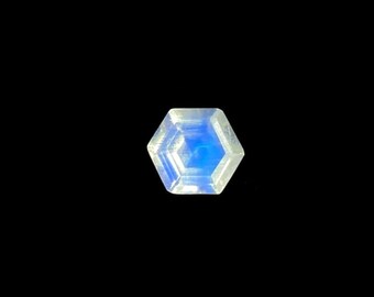 May include: A hexagonal iridescent gemstone with a blue center and a white outer edge.