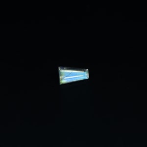 May include: A light blue gemstone with a rectangular shape.
