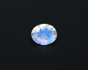 May include: A round, iridescent gemstone with a blue and white color.