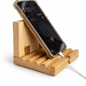 May include: A set of three ceramic mugs with a speckled, cream-colored glaze. Each mug features a different hand-painted design: a blue and green leaf, a yellow flower, and a red berry. The mugs have a simple, rounded shape.