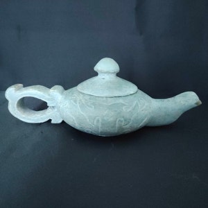 A rare archaic green jade teapot with carving, Shang dynasty (1600-1046 BC)