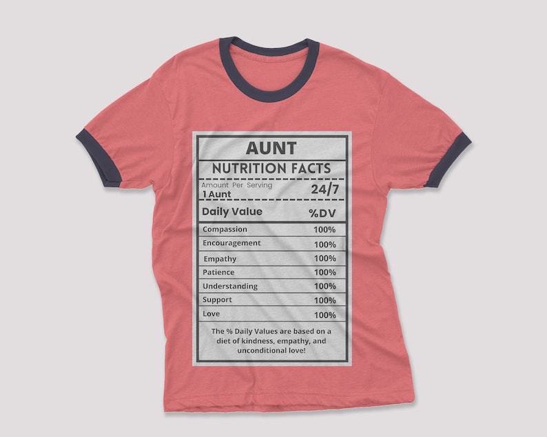 May include: A red t-shirt with a black and navy blue ringer. The shirt features a white graphic of a nutrition facts label with the title "AUNT" and the text "24/7". The label lists various qualities of an aunt, such as compassion, encouragement, empathy, patience, understanding, support, and love, all with a value of 100%.