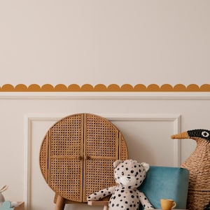 May include: A children's room scene featuring a teal armchair, a stuffed leopard, and a woven cabinet. A wooden toy box with a bunny and a woven penguin are also present. A scalloped border in a warm orange colour decorates the wall.