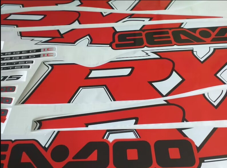 Peut inclure: Graphiques de moto rouge et blanc avec inscription noire "SE400" et "RY" avec un contour blanc. Les graphiques sont sur un fond blanc.