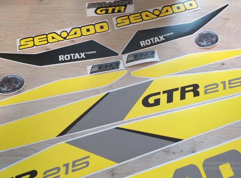 以下が含まれることがあります： 黄色と黒のSea-Doo GTR 215デカールセット。デカールには、Sea-Dooロゴ、GTR 215モデル名、Rotax Powerロゴが描かれています。
