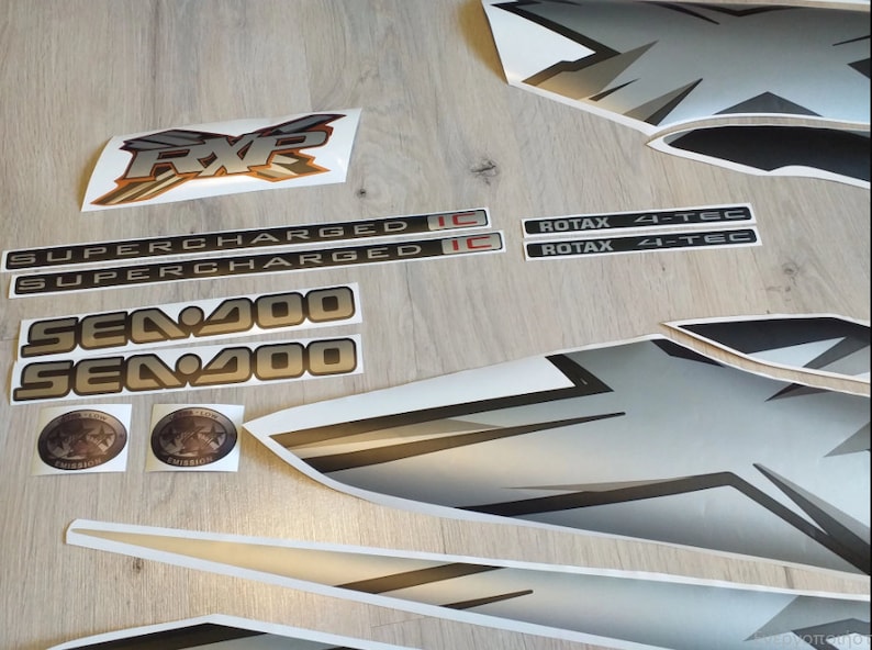 Puede incluir: Un conjunto de calcoman&iacute;as negras y plateadas para una moto acu&aacute;tica Sea-Doo. Las calcoman&iacute;as incluyen las palabras "Sea-Doo", "Supercharged", "RXP", "Rotax" y "4-Tec".