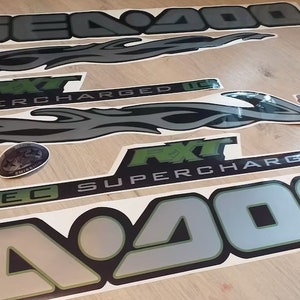 May include: A set of black and green Sea-Doo decals with the text "Sea-Doo", "RXT", "Supercharged", and "4-TEC".