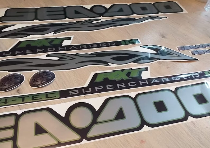 May include: A set of black and green Sea-Doo decals with the text "Sea-Doo", "RXT", "Supercharged", and "4-TEC".