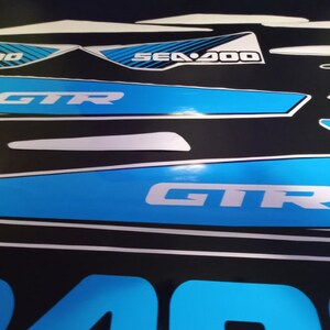 May include: A set of blue and white Sea-Doo GTR decals. The decals feature the Sea-Doo logo, the GTR logo, and the words "Intelligent Throttle Control".