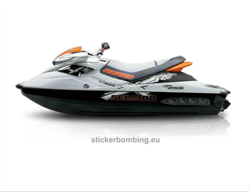 Puede incluir: Una moto acu&aacute;tica Sea-Doo Spark 2 plazas blanca y negra con detalles naranjas. La moto acu&aacute;tica tiene un dise&ntilde;o gr&aacute;fico en blanco y negro con el texto "Sea-Doo" y "Spark" en el lateral.