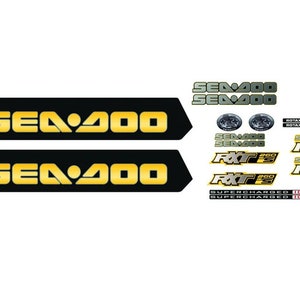 Puede incluir: Un conjunto de calcoman&iacute;as Sea-Doo negras y doradas. Las calcoman&iacute;as incluyen las palabras "Sea-Doo", "RXT", "RXT-260", "Supercharged" y "Botax 2-Tec".