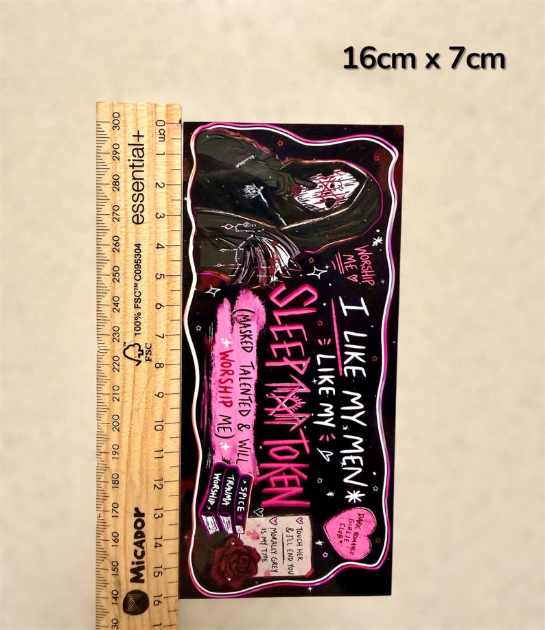 May include: A rectangular sticker, 16cm x 7cm, with a dark background and a gothic theme. The sticker features a hooded figure with a skull face, and text that reads "SLEEP MAN TOKEN" and "I LIKE MY MEN".