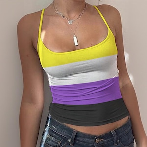 May include: A sleeveless tank top with a yellow, white, purple, and black striped design. The top has thin spaghetti straps and a scoop neckline. The model is wearing blue jeans. A silver necklace with a pendant is visible.