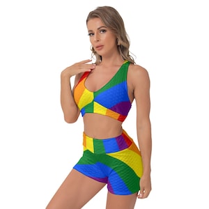 May include: A two-piece workout set featuring a rainbow-coloured sports bra and matching shorts. The fabric has a textured, quilted look.